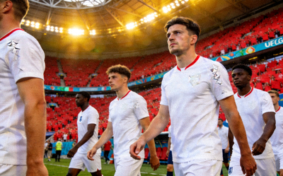 英格兰国家男子足球队在欧洲杯决赛中入场，球员们神情专注，白色球衣简洁大方